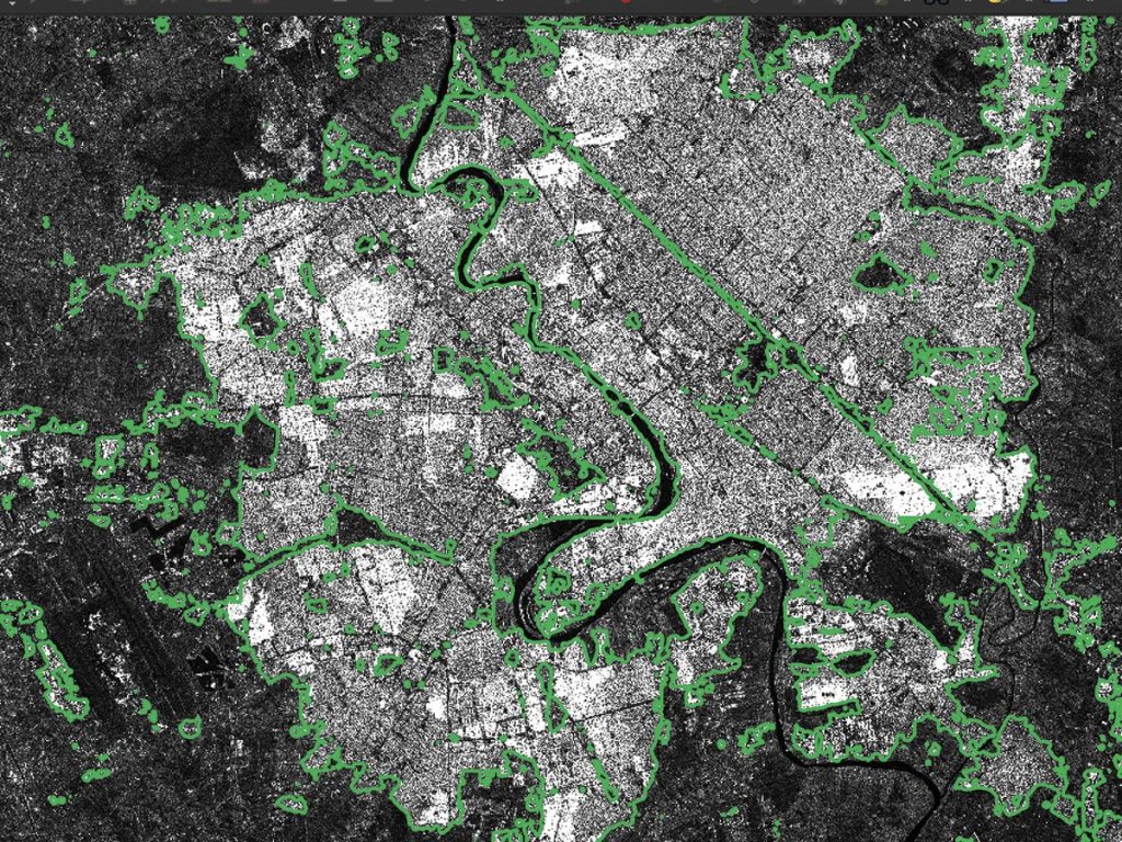 Radar image of Baghdad with predicted building areas outlined in green.